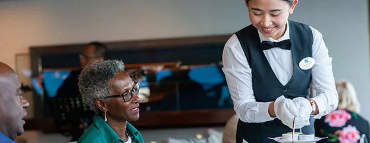 A couple being served afternoon tea by a staff member