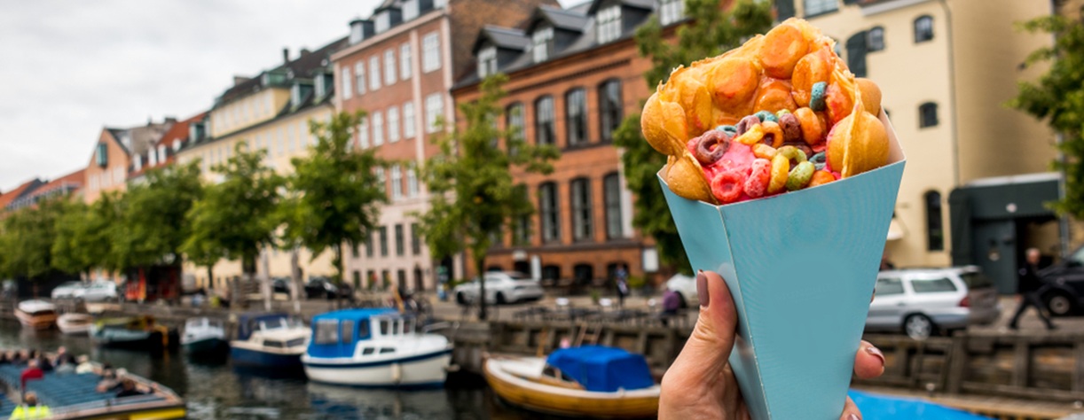 Person holding a waffle on a bridge over the river 