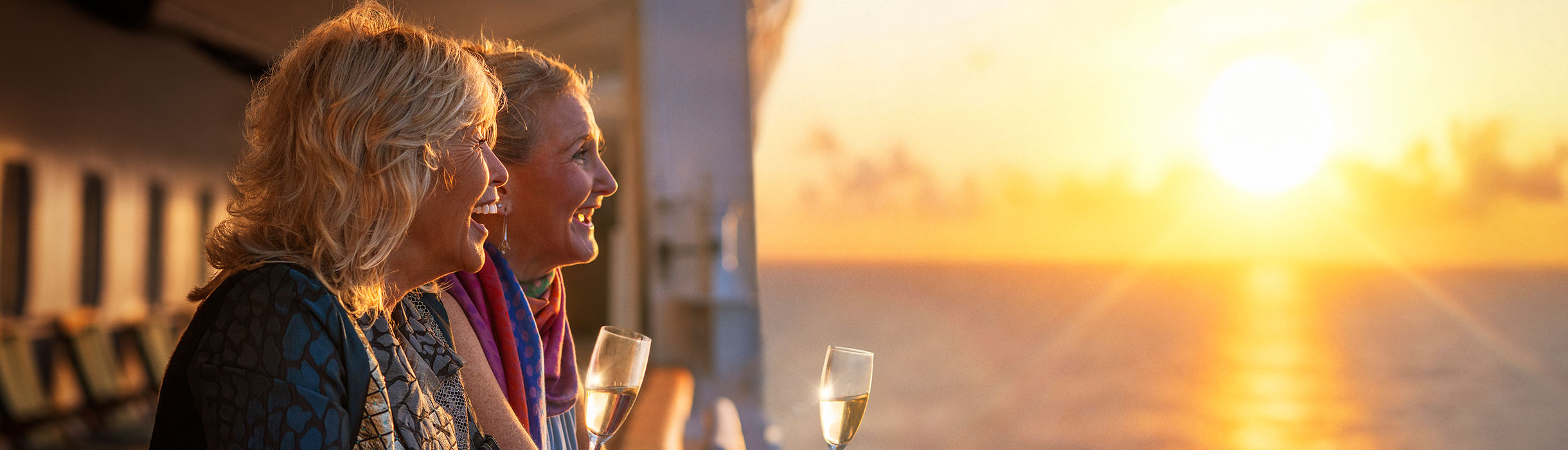 Guests having drinks on deck at sunset