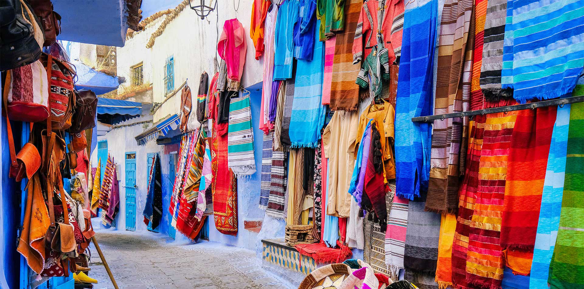 Moroccan handmade crafts, carpets and bags hanging in the Chefchauen, Morocco. 