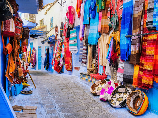 Moroccan handmade crafts, carpets and bags hanging in the Chefchauen, Morocco
