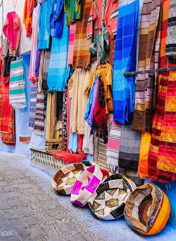 Moroccan handmade crafts, carpets and bags hanging in the Chefchauen, Morocco. 