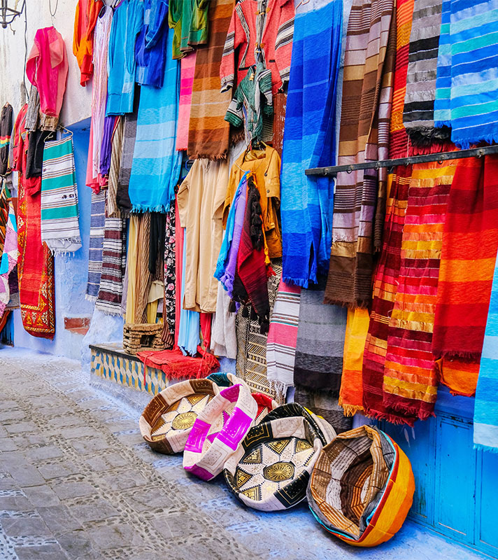 Moroccan handmade crafts, carpets and bags hanging in the Chefchauen, Morocco. 