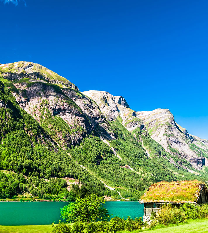 Typical wooden red buildings next to Sognefjord in Norway
